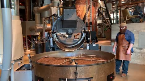 Fresh-aromatic-coffee-beans-spilling-out-of-a-factory-sized-coffee-roaster-at-the-Starbucks-Reserve-Seattle-Roastery