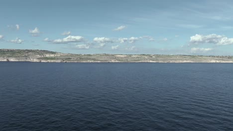 Slow-aerial-flight-over-the-Mediterranean-sea-towards-the-coastal-village-of-Ghar-Lapsi-on-the-Island-of-Malta