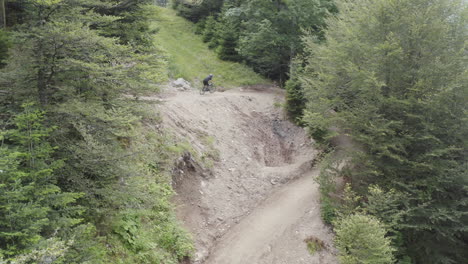 Aerial-View-of-mountain-biker-riding-downhill-on-a-bike-trail-in-the-vosges-mountains,-France