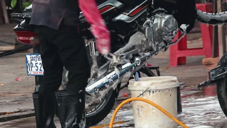 Medium-Shot-of-Cleaning-Raised-Motorbike