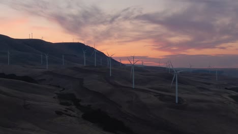 Wunderschöne-Luftlandschaftsansicht-Von-Windkraftanlagen-Auf-Einem-Windigen-Hügel-Während-Eines-Farbenfrohen-Sonnenaufgangs