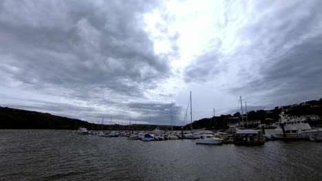 Time-lapse-of-stormy-clouds-rushing-over-marina-with-boats