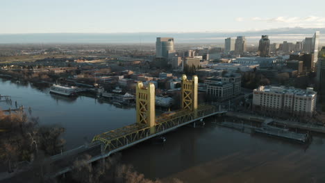 Aerial-drone-right-parallax-of-Tower-Bridge-and-Downtown-Sacramento,-CA,-including-Old-Sacramento---State-Capitol-in-background-during-sunrise