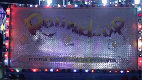 The-sign-for-the-carnival-ride,-"Round-Up"-lighting-up-at-night