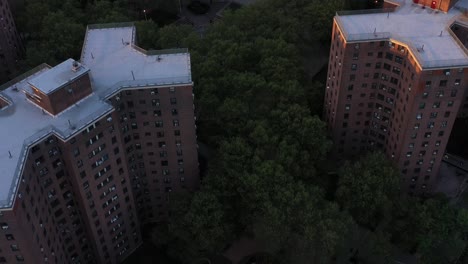 Aerial-footage-pans-up-from-housing-projects-of-Harlem-to-reveal-part-of-the-New-York-City-skyline-at-sunrise-golden-hour