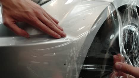 Close-up-to-PPF-installation-process-on-silver-sports-car