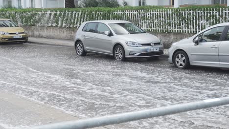 Nahaufnahme-Eines-Tiefen-Wassers-Und-Eines-Durchfahrenden-Autos-Nach-Starkem-Regen-In-Alcudia-Auf-Der-Insel-Mallorca-In-Spanien