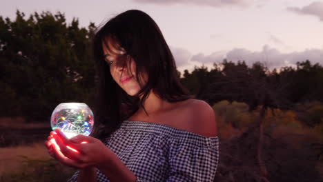 An-alluring-mysterious-girl-with-a-magic-crystal-orb-glowing-in-an-enchanted-fantasy-land