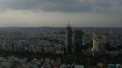 Afternoon-drone-footage-flying-over-rooftops-of-Binh-Thanh-district-of-Ho-Chi-Minh-City,-Vietnam-featuring-key-buildings-from-high-to-low-angle-with-high-air-pollution