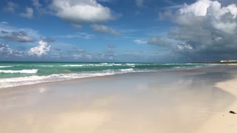Slow-motion-camera-pan-along-caribbean-white-sandy-beach-with-cloud-formations