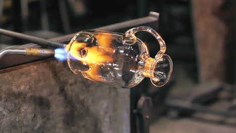 Glass-artist-rotates-vase-while-heating-it-with-blowtorch
