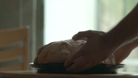 Person-letting-down-a-piece-of-pan-de-muerto-in-a-table-in-slow-motion