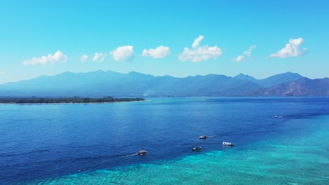 Peaceful-gateway-of-tropical-coastline-in-Indonesia-with-blue-sea-and-turquoise-lagoon-full-of-boats-sailing-around-coastline-of-islands-on-bright-blue-sky-background