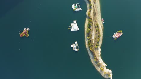 Aerial-overhead-view-of-floating-houses-on-a-lake-near-a-small-island