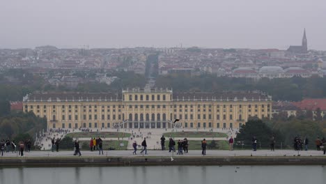 High-above-view-of-Schönbrunn-castle-grounds-and-Vienna-Panorama-on-grey-and-foggy-autumn-day-with-pond