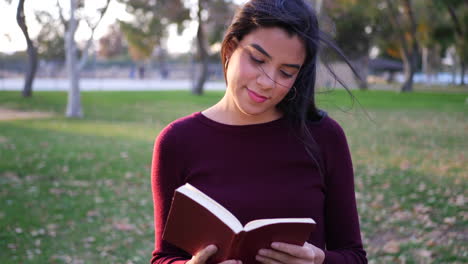 A-female-college-student-reading-and-studying-a-textbook-before-literature-class-on-campus-SLOW-MOTION
