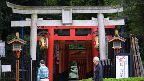 Cámara-Lenta-De-Japoneses-Caminando-Frente-A-Un-Camino-Torii-En-Hanazono-Inari,-Parque-Ueno