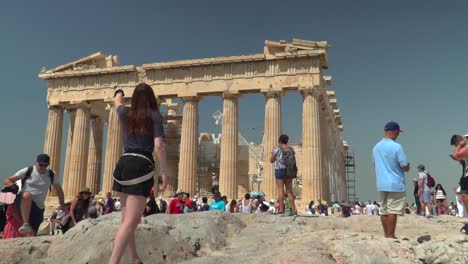 Masses-of-tourists-at-Akropolis-in-Greece,-taking-pictures-on-bright-day-SLOW-MOTION