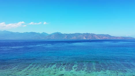 Eine-Atemberaubende-Landschaft-Mit-Blauem,-Ruhigem-Meer-Unter-Dem-Strahlend-Blauen-Himmel,-Insel-Lombok,-Indonesien-–-Luftaufnahme