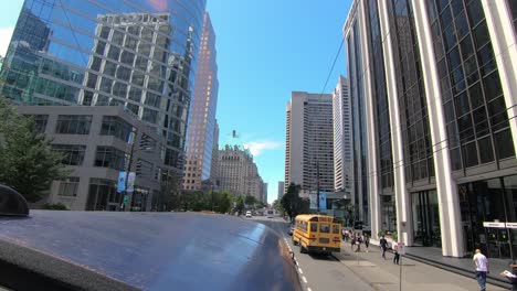 Driving-through-the-street-in-Seattle-with-huge-modern-buildings-and-trees-by-the-road