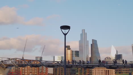 People-walking-across-the-Millenium-Footbridge-in-front-of-London-skyline