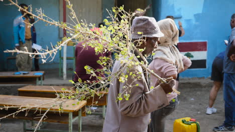 Ein-Alter-Mann-Aus-Ziway-Geht-Während-Einer-Wohltätigkeitsveranstaltung-Um-Eine-Gruppe-Von-Leuten-Herum,-Die-An-Der-Restaurierung-Einer-Schule-In-Ziway,-Äthiopien,-Arbeiten