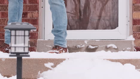 Low-pov-shot-of-man-shoveling-snow-off-porch