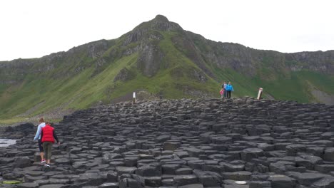 Tourists-Visiting-And-Having-Fun-At-The-Hexagonal-Rock-Formations-At-The-Giant's-Causeway-In-Northern-Ireland-At-Daytime