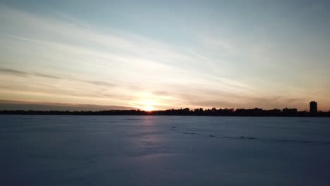 Sonnenuntergang-über-Einem-Zugefrorenen-See,-Schnee,-Kamera-Geht-Vorwärts
