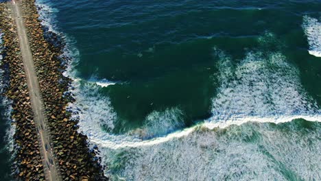 Looking-down-over-Gold-Coast-seawall-with-waves-crashing-in-at-sunset