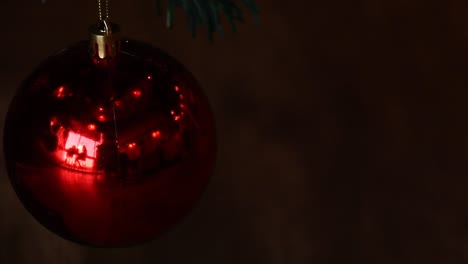 Conceptual-video-of-twinkling-lights-reflected-on-a-red-Christmas-ball-ornament-against-a-dark-background