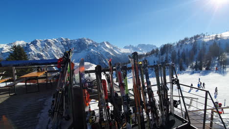 Skis-and-snowboards-lined-up-on-rack-will-people-rest-in-the-chalet