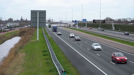 Traffic-on-Netherlands-highway,-camera-pan-from-bridge