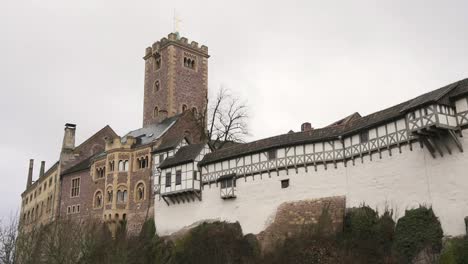 Reveal-shot-of-medieval-Wartburg-castle-behind-wall-in-east-Germany