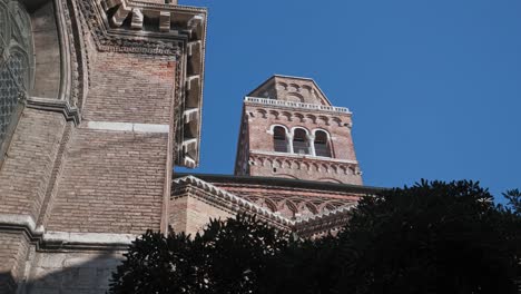 Baroque-bell-tower-of-a-Basilica-di-Santa-Maria-Gloriosa-dei-Frari,-antique-church-in-Venice,-northern-Italy,-Low-angle-shot