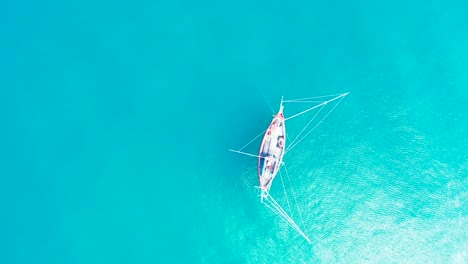 Fischerboot-Mit-Hängenden-Netzen-über-Ruhigem,-Klarem-Wasser-Der-Türkisfarbenen-Lagune,-Das-Sonnenstrahlen-In-Einer-Wunderschönen-Bucht-In-Fidschi-Reflektiert