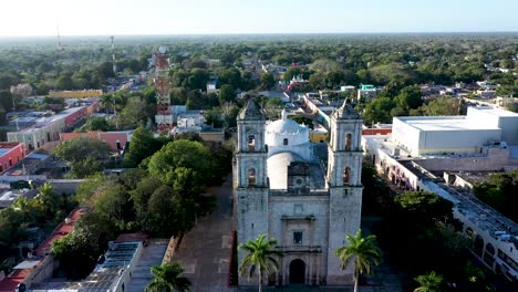 Early-morning-aerial-descent-with-camera-pitch-up-to-front-of-the-Cathedral-de-San-Gervasio-in-Valladolid,-Yucatan,-Mexico