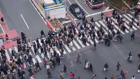 People-crossing-a-cross-walk-in-Shibuya,-Tokyo,-Japan