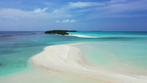 Unspoiled-white-sandy-stripe-beach-washed-by-calm-clear-water-of-turquoise-lagoon-near-beautiful-tiny-tropical-island-in-Maldives