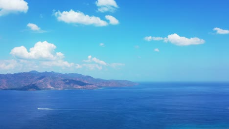 Strahlend-Blauer-Himmel-Mit-Gefrorenen-Weißen-Wolken,-Die-über-Berginseln-Hängen,-Umgeben-Von-Endlosem-Ozean,-Indonesien