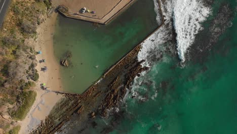 Aerial-drone-view-straight-from-top-of-rock-pool-on-rocky-shoreline-with-circling-motion