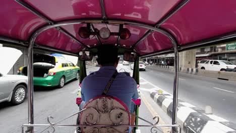 Man-Captured-From-Behind-While-Driving-Tuk-Tuk-Vehicle-On-The-Road-In-Bangkok-Thailand---Closeup-Shot