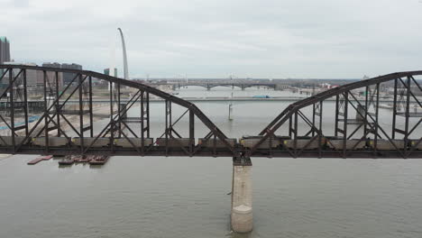 Aerial-static-shot-of-train-and-traffic-moving-across-Mississippi-River-bridges