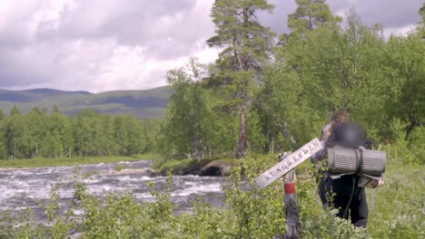 Hikers-walking-next-to-a-big-river-along-the-kings-path-in-Sweden