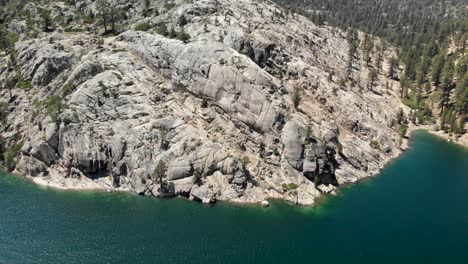 Aerial-rotating-shot-of-a-large-granite-slab-on-the-edge-of-a-high-Sierra-lake-in-California