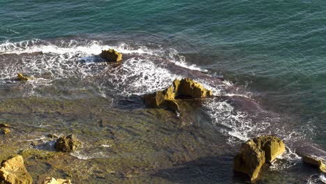 Rocky-coastline-with-subtropical-waves-breaking-over-submerged-reef,-Spain