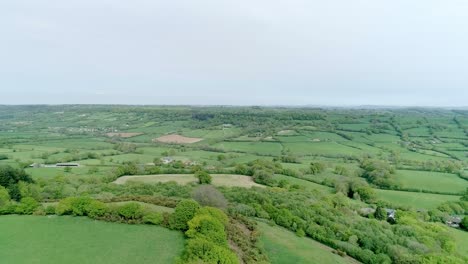 Slow-aerial-panorama,-high-over-a-vast-tapestry-of-fertile-green-land-in-Western-Europe