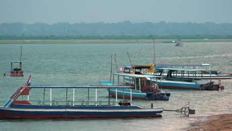 Barcos-Turísticos-Vacíos-En-Camboya-Mientras-Un-Pequeño-Grupo-Nada-En-El-Lago