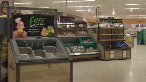 Slow-motion-interior-empty-UK-supermarket-dolly-right-passing-veg-market
