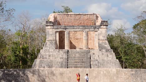 Tourists-visiting-Temple-of-the-Bearded-Man-or-the-North-Temple-in-the-Great-ball-court,-Chichen-Itza-archaeological-site